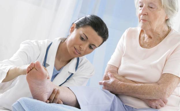 Una doctora examina a una anciana.