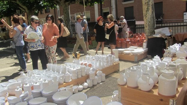 Visitantes a la feria contemplan las piezas de uno de los stands de alfarería tradicional situado en una de las plazas del centro de Navarrete. :: p. h.
