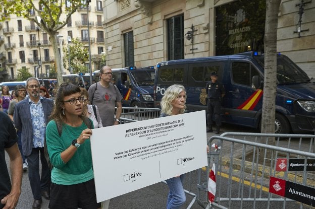 Papeleta. Dos concejalas de la CUP portan una reproducción de una papeleta para el referéndum, durante un acto reivindicativo ayer en Barcelona. En el lateral, la papeleta oficial. :: Alejandro García / EFe