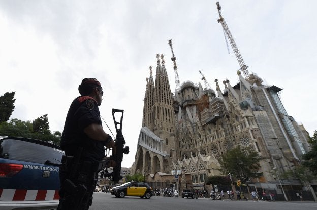 Un mosso vigila la Sagrada Familia el pasado 19 de agosto, tras los atentados de Barcelona y Cambrils. :: lluis gené / AFP