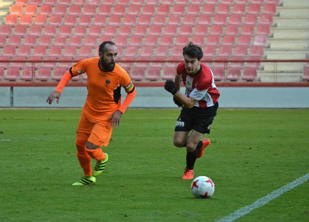 Navarro saca el balón del área visitante presionado por el delantero blanquirrojo Rubén Peña. :: sergio martínez
/