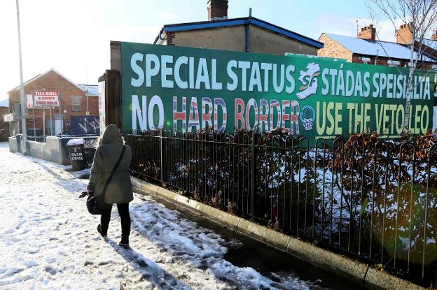 Una joven camina junto a un cartel que pide en Belfast un estatus especial para Ulster. :: Paul FAITH / afp
/