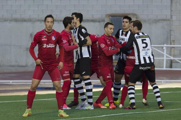 Al fondo, Sabando, al que se le anuló un gol, busca posición para rematar entre la defensa rojilla. /Donézar