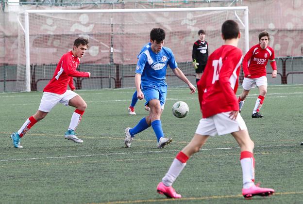 Un jugador del Polideportivo Juventud trata de despejar, rodeado de contrarios. :: fernando Díaz/