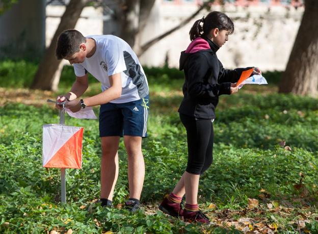 Dos escolares sellan su tarjeta de control en una baliza del recorrido de orientación. :: F.D.
/