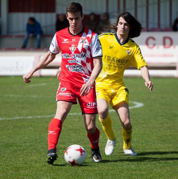 Alberto Gil conduce el balón, perseguido por Isra. :: díaz uriel/