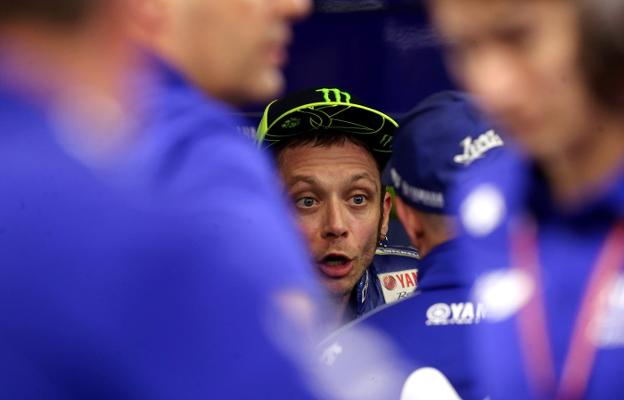 El piloto italiano Valentino Rossi habla con los miembros de su equipo tras la carrera. :: rEUTERS/