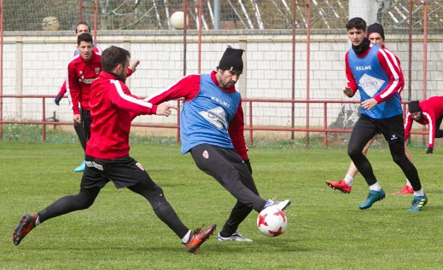 Muneta y César Remón, dos de los hombres que pueden volver hoy a la alineación de la UDL, pugnan por un balón en el entrenamiento de ayer. / FERNANDO DÍAZ