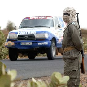 AMENAZADOS. Un participante en una edición anterior del rally atraviesa una carretera mauritana con vigilancia policial. / AFP/
