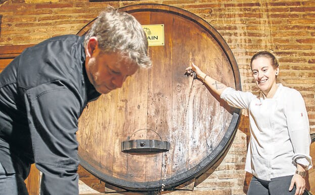 Álvaro Díez y Yoli Chicote escancian un vaso de sidra natural de la 'kupela' de Zapiain./Justo Rodriguez