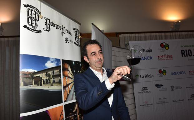 Zigor Cornago posa con un vino de Bodegas Perica en el Campo de Golf de Logroño. / MIGUEL HERREROS